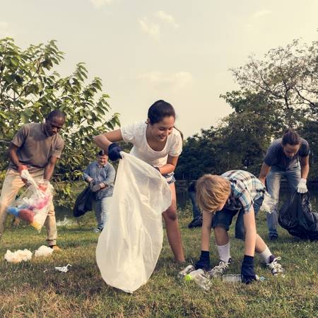 80420788 diverse group of people picking up trash in the park volunteer community service